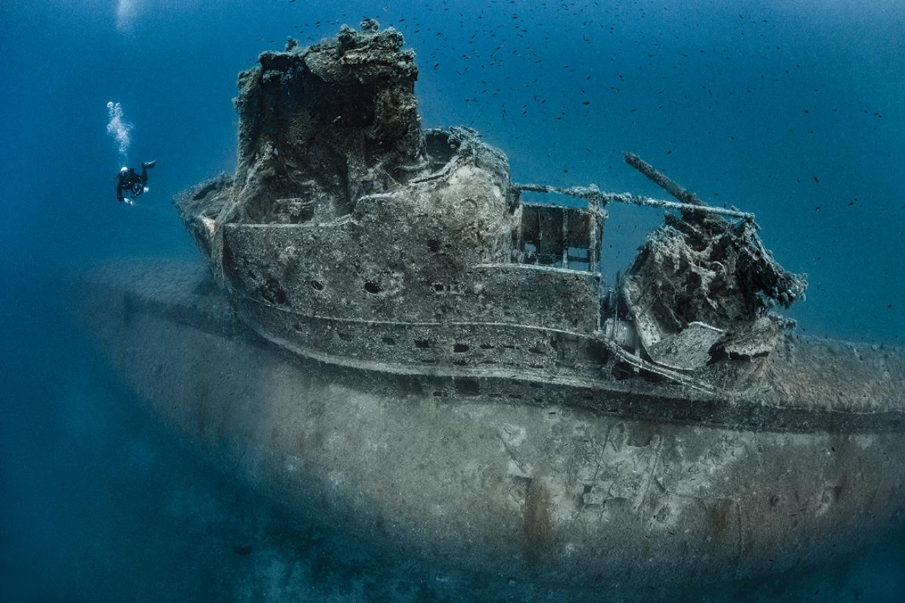 Diver swims near conning tower of the HMS Perseus.