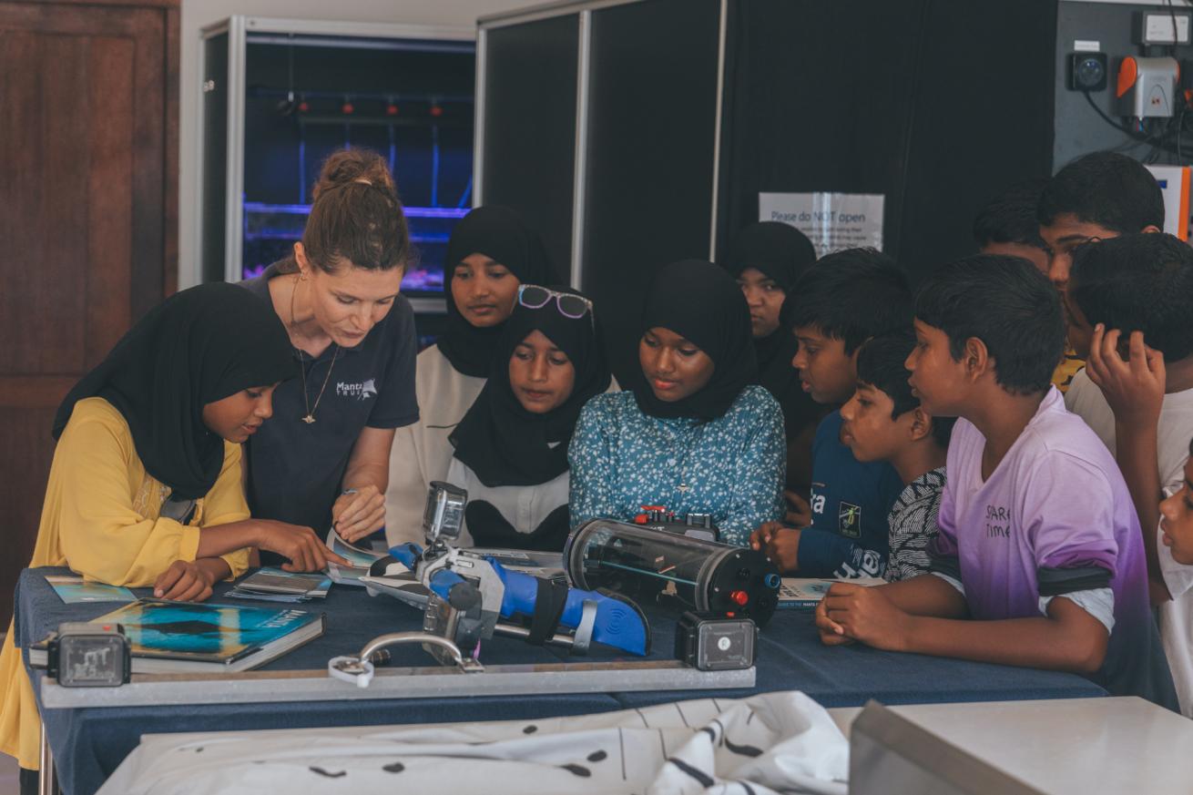 Manta Trust marine biologist Miri teaches school students from Laamu, Maldives, about the manta ray research equipment, during a community experience day.