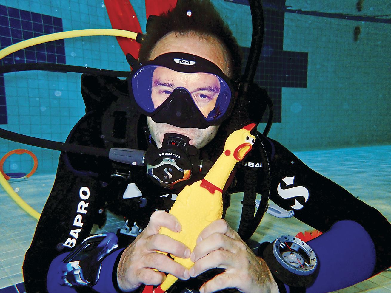 a diver practicing buoyancy skills with a rubber chicken in a pool