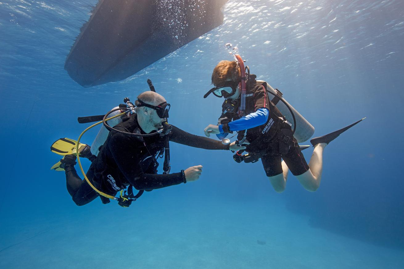an adult diver checks on a child diver