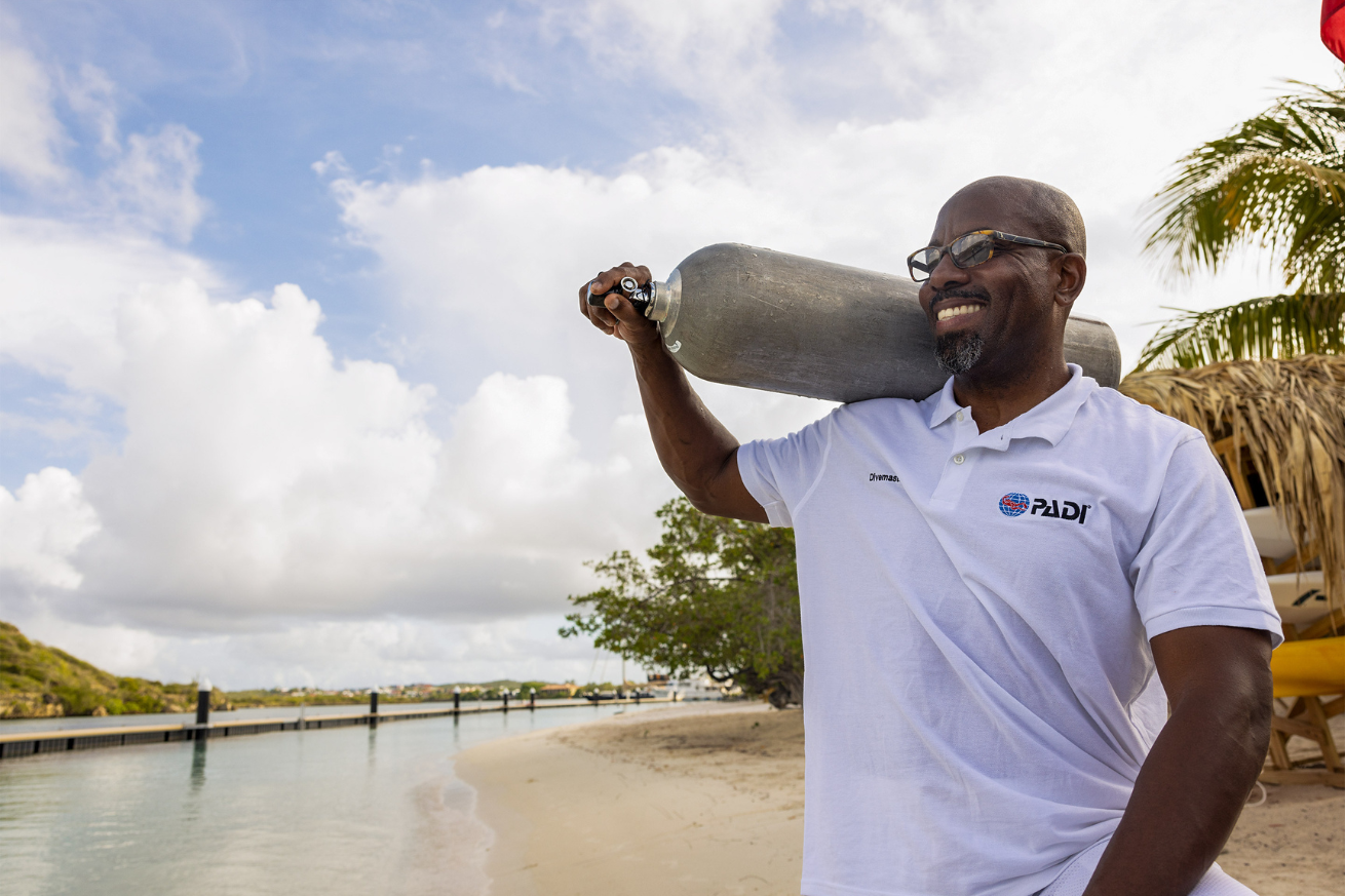 Man holding scuba tank and smiling