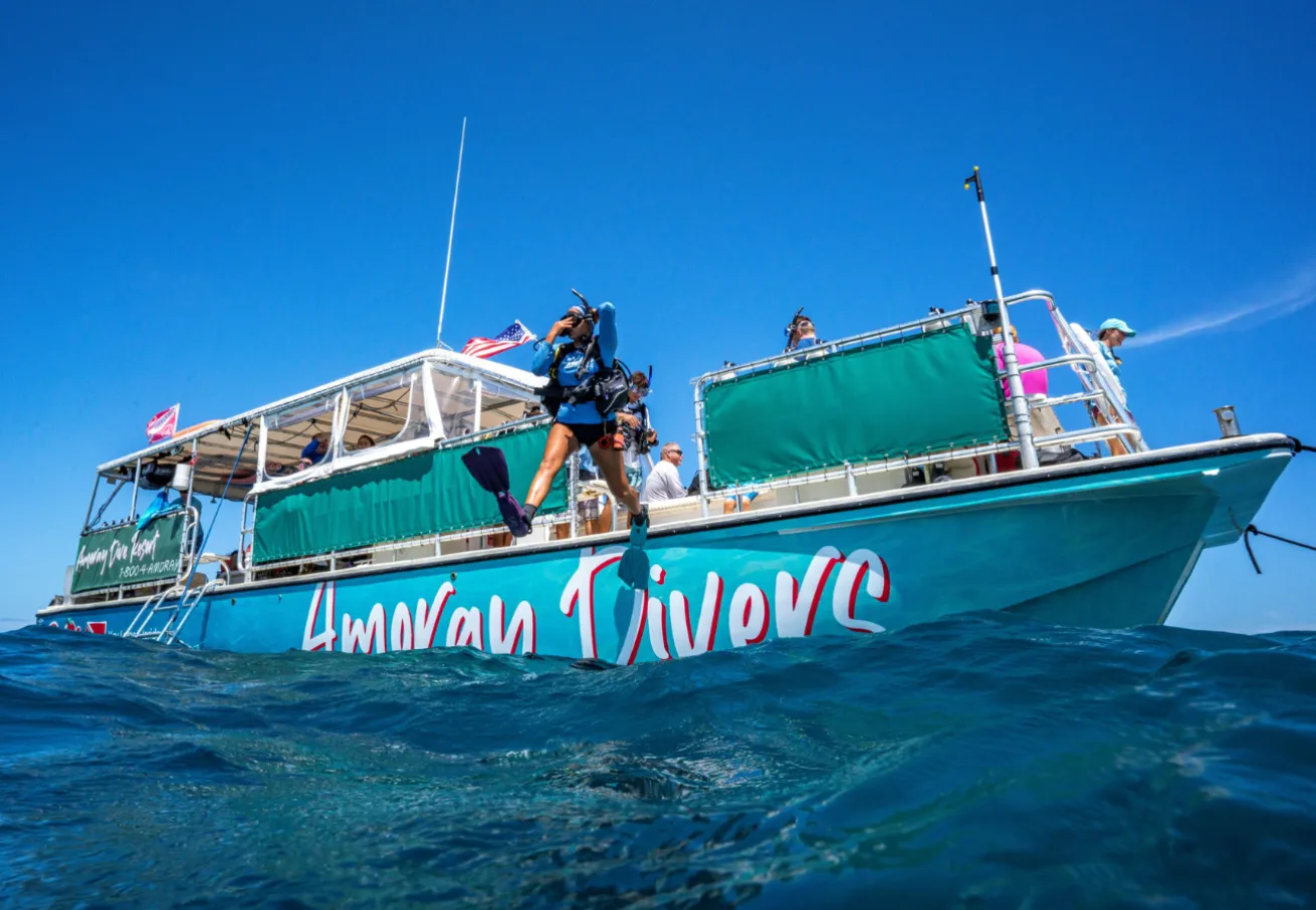 A person diving off a boat in Key Largo