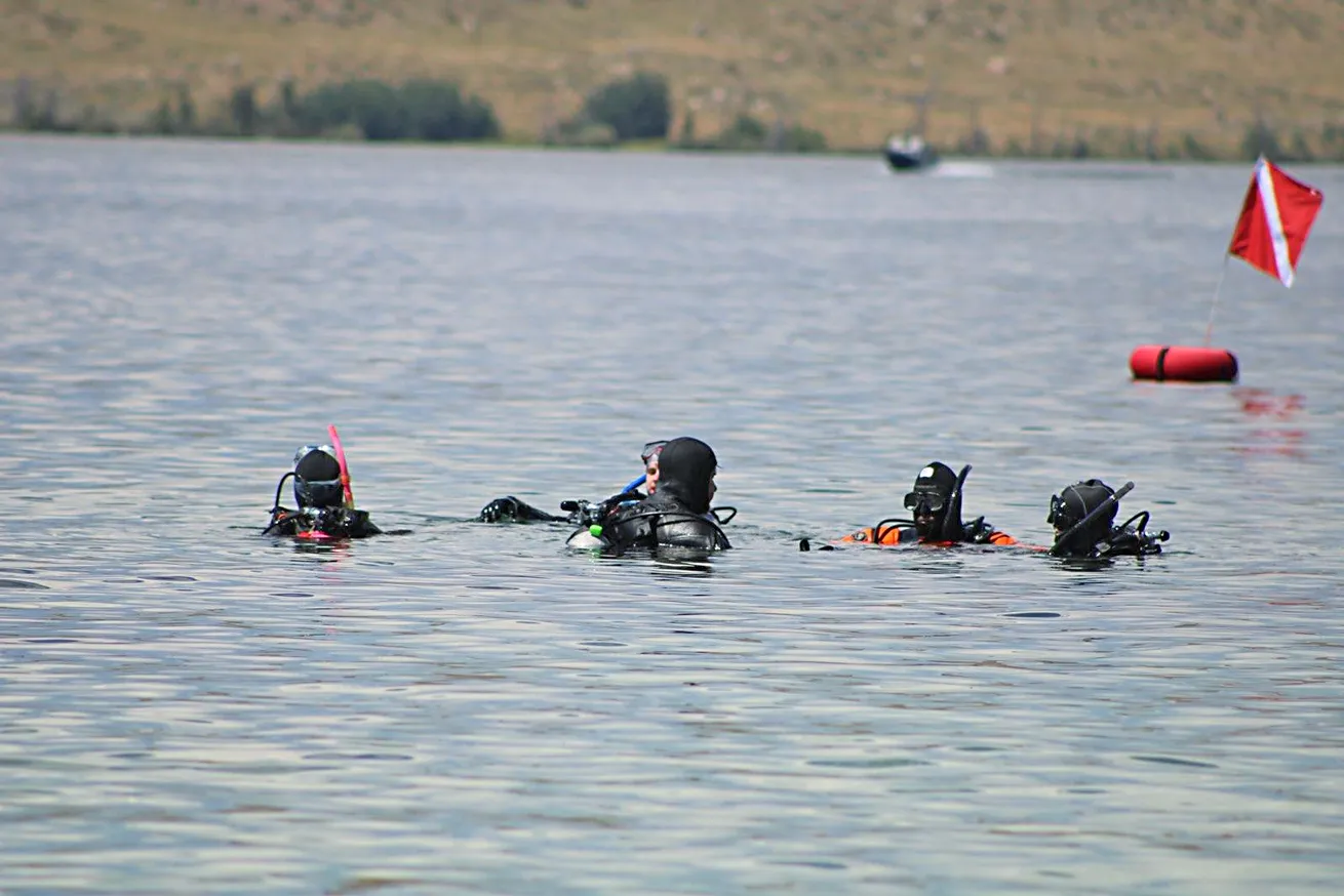 Divers surface on the lake.

