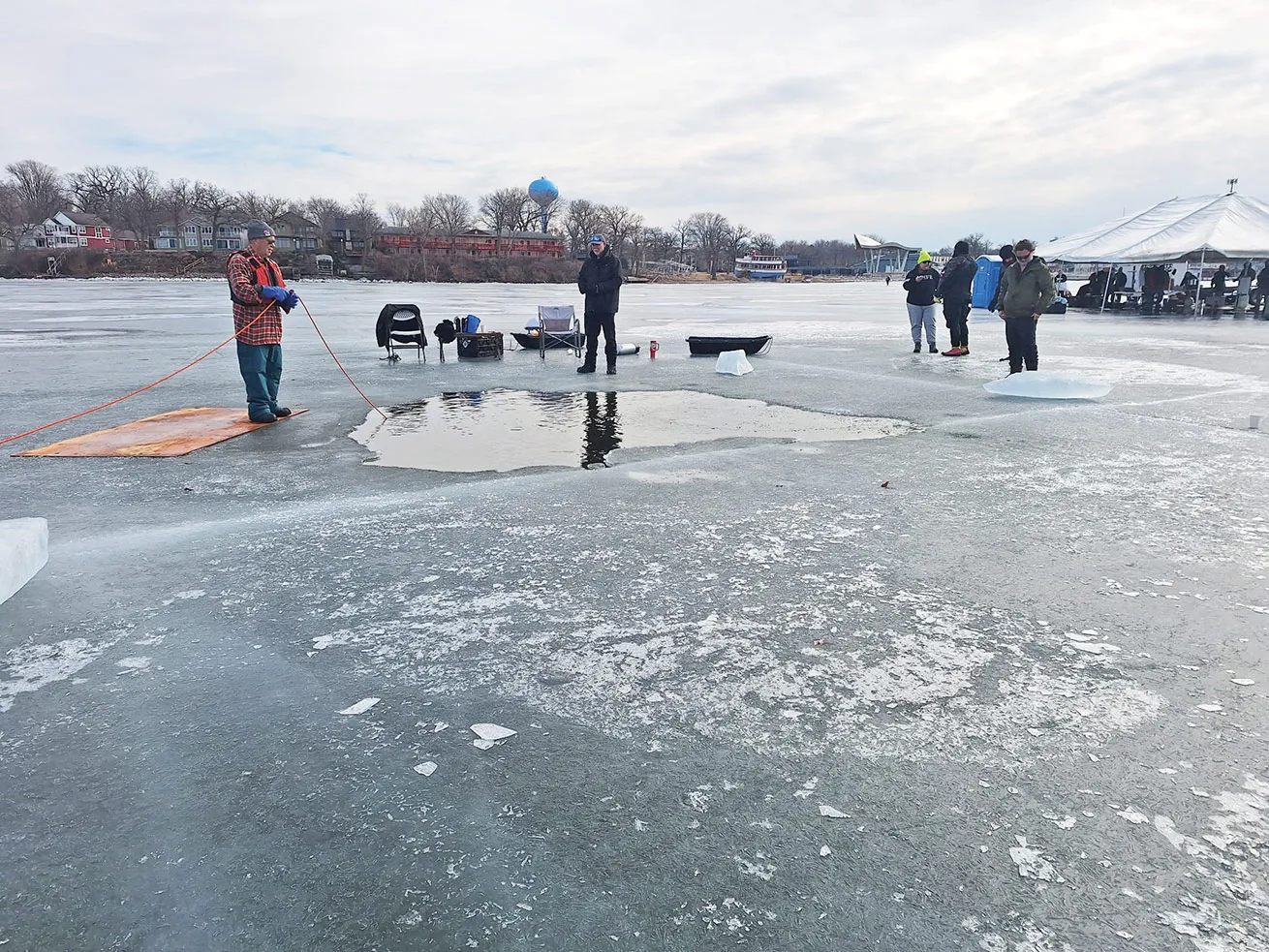 A crew stands watch at one of three ice holes.