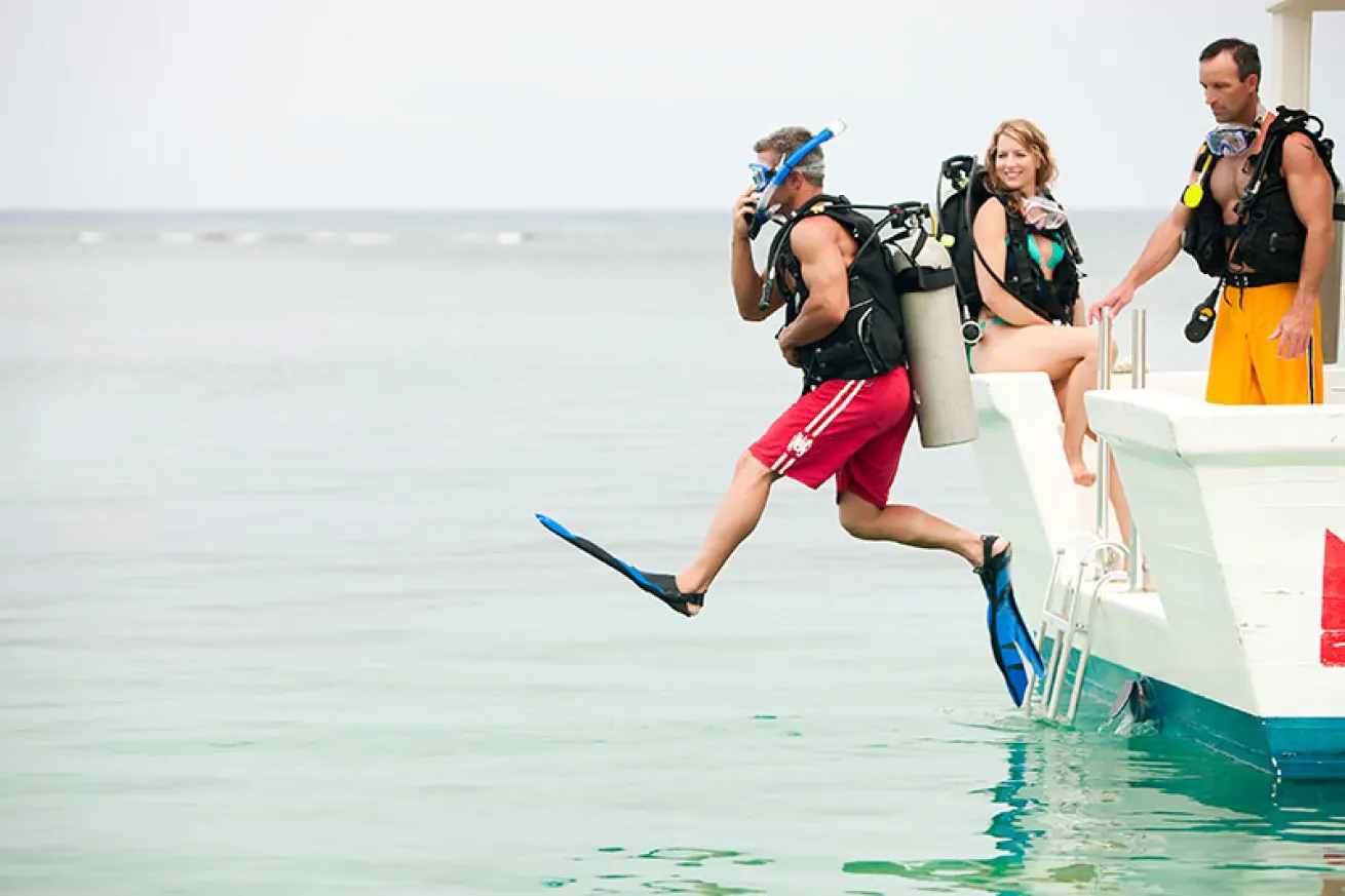 Scuba diver giant-striding off dive boat