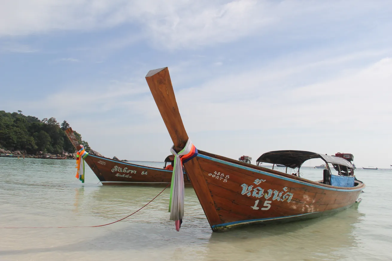 Long-tail boats on a beach in southern Thailand.