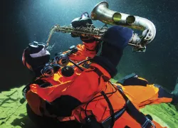 Plura-Cave-concert C-Ha CC Akon-Skog-Erlandsen-aka-Jazzathelete-showing-off-his-saxophone-under-water-Photo-Pekka-Tuuri_edit.jpg.webp