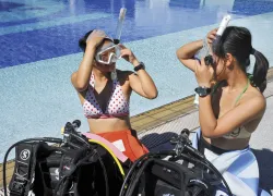 women-by-pool-putting-on-masks.jpg.webp